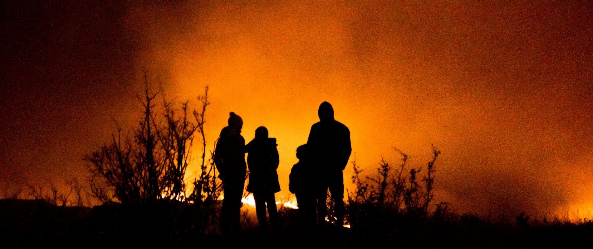 Family observing wildfire from safe distance. Contemplating how to help.