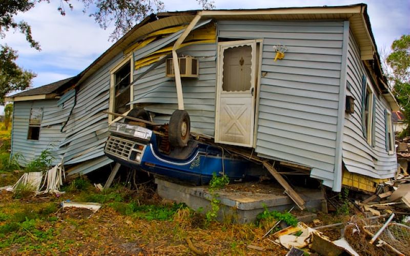 Natural Disaster Hurricane force winds lifted entire house and slammed it onto blue pickup truck.